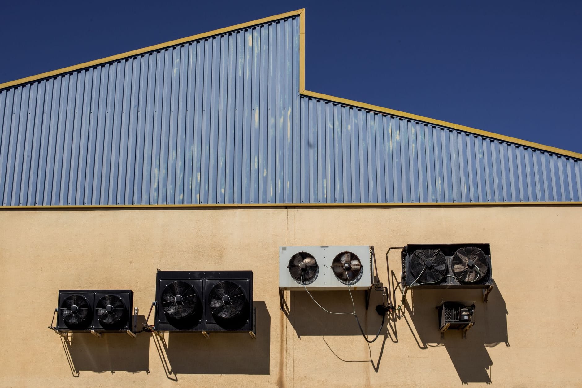 Commercial heat pump installation — cascaded air-source units and plant-room pipework on a UK site